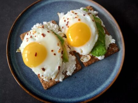 Crackers met cottage cheese, avocado en spiegelei